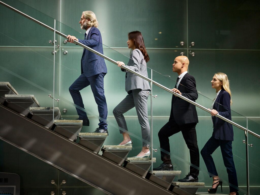 Real employees progressing through career stages with mentorship and growth opportunities in a modern workplace to represent career pathing framework.